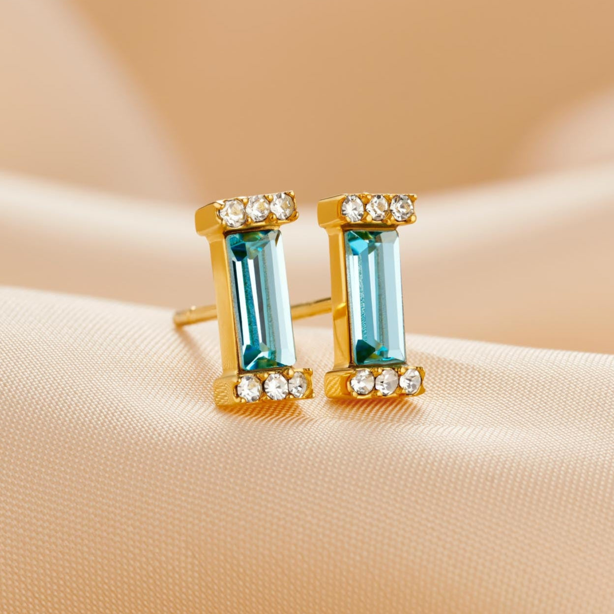 Aquamarine baguette cut crystals set in a sterling silver setting that has been plated in 18 carat gold. There are tiny white crystals in the ends of each setting. Earrings have sterling silver stud posts, plated with 18 carat gold.