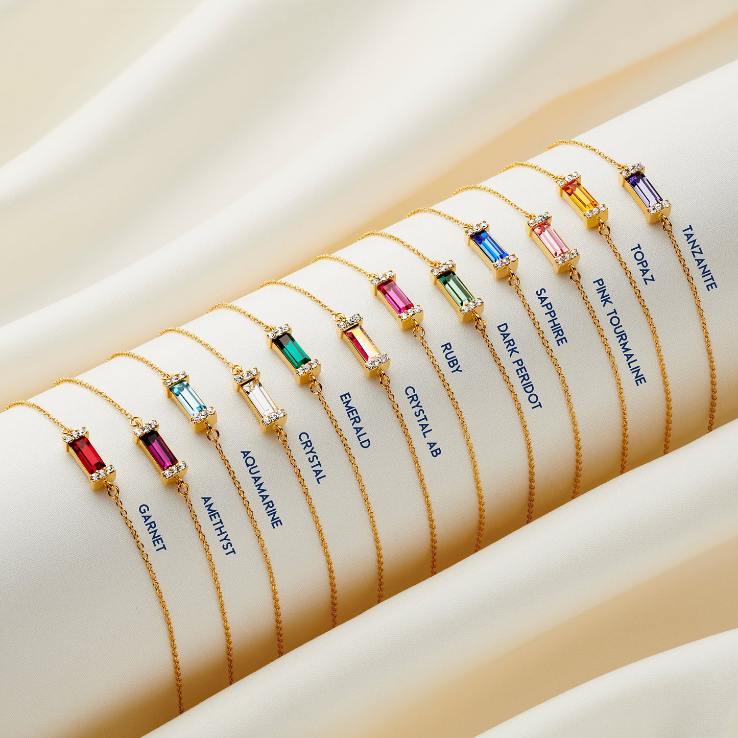 Birthstone bracelets featuring baguette cut stones in a contemporary setting on fine gold trace chains. There is a different birthstone for the 12 birthday months of the year. By jewellery designer Claudette Worters