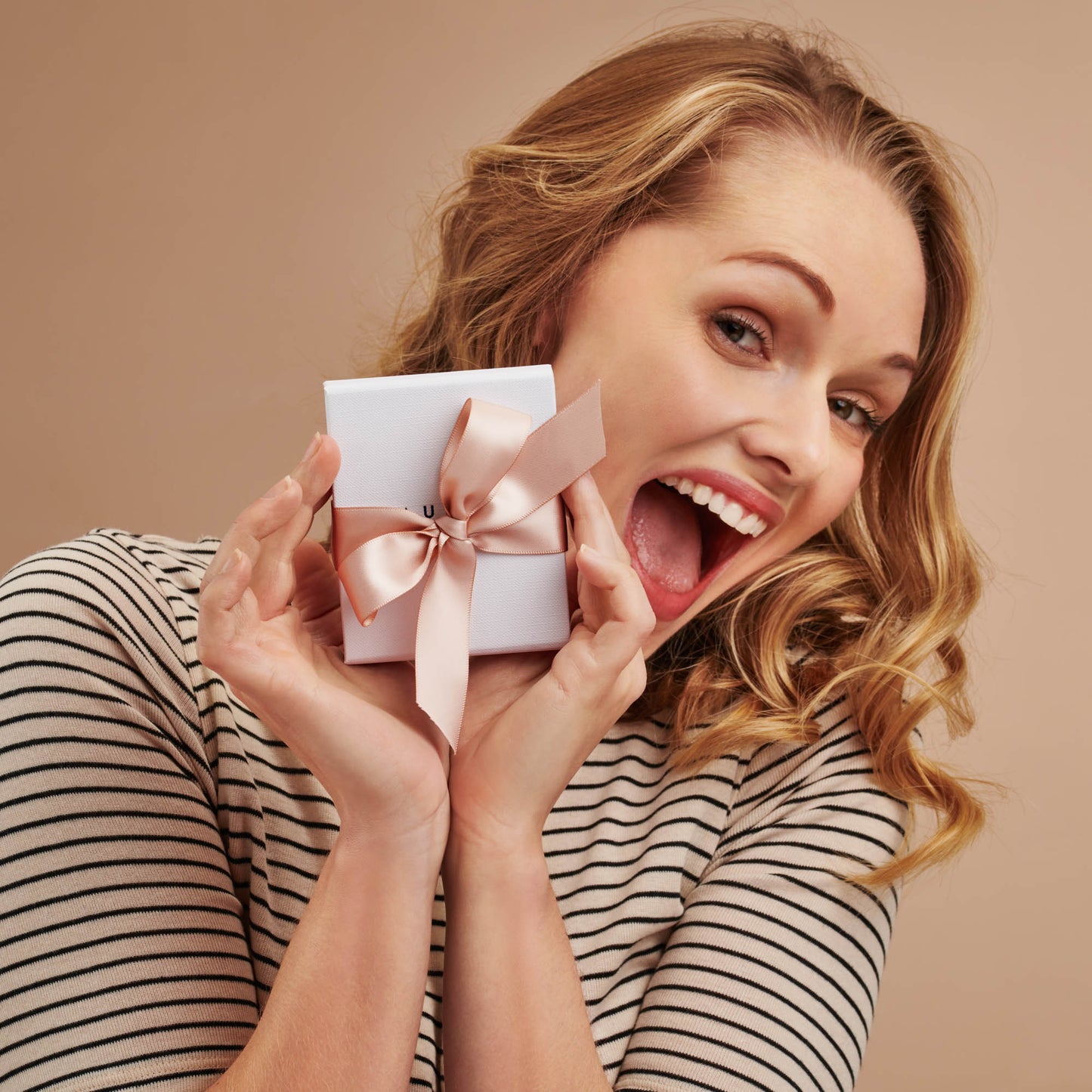 Lady in a striped t-shirt holding Claudette Worters packaging