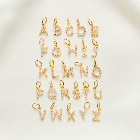 Uppercase gold vermeil letter pendants set with real white diamonds. Full alphabet shown.