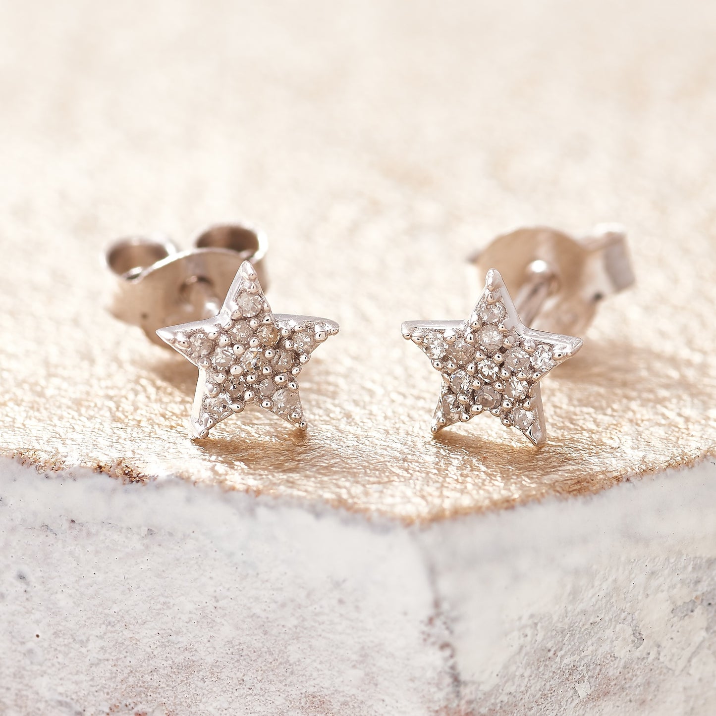 Tiny sterling silver star studs pavé set with tiny white diamonds. Suds have sterling silver posts and butterfly back fastenings. By Claudette Worters.
