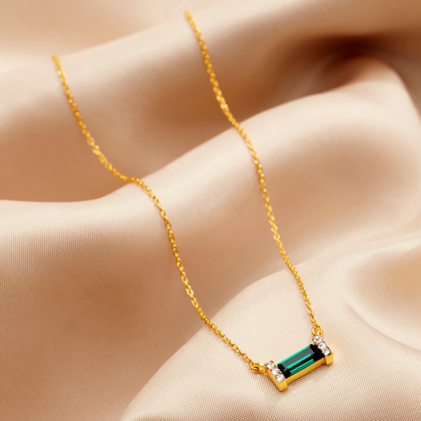 Green emerald baguette cut Swarovski crystal necklace in 18 carat gold vermeil. Pendant is set on a fine gold trace chain. by Claudette Worters.