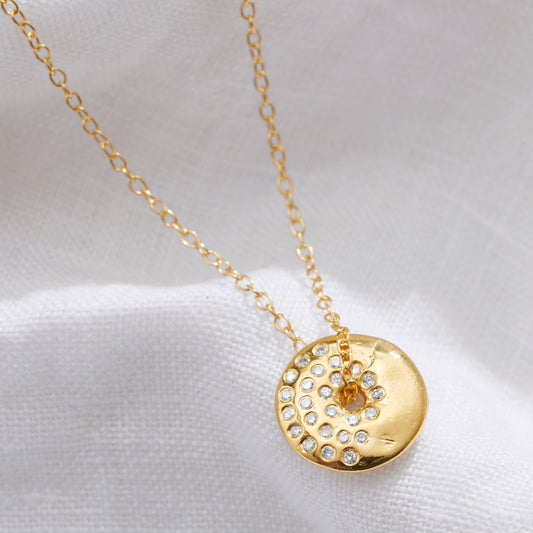 Gold vermeil Waxing Gibbous moon pendant necklace by Claudette Worters. Softly textured lunar disc pendant with small natural diamonds arranged to depict the moon phase, spinning freely on a delicate gold trace chain.