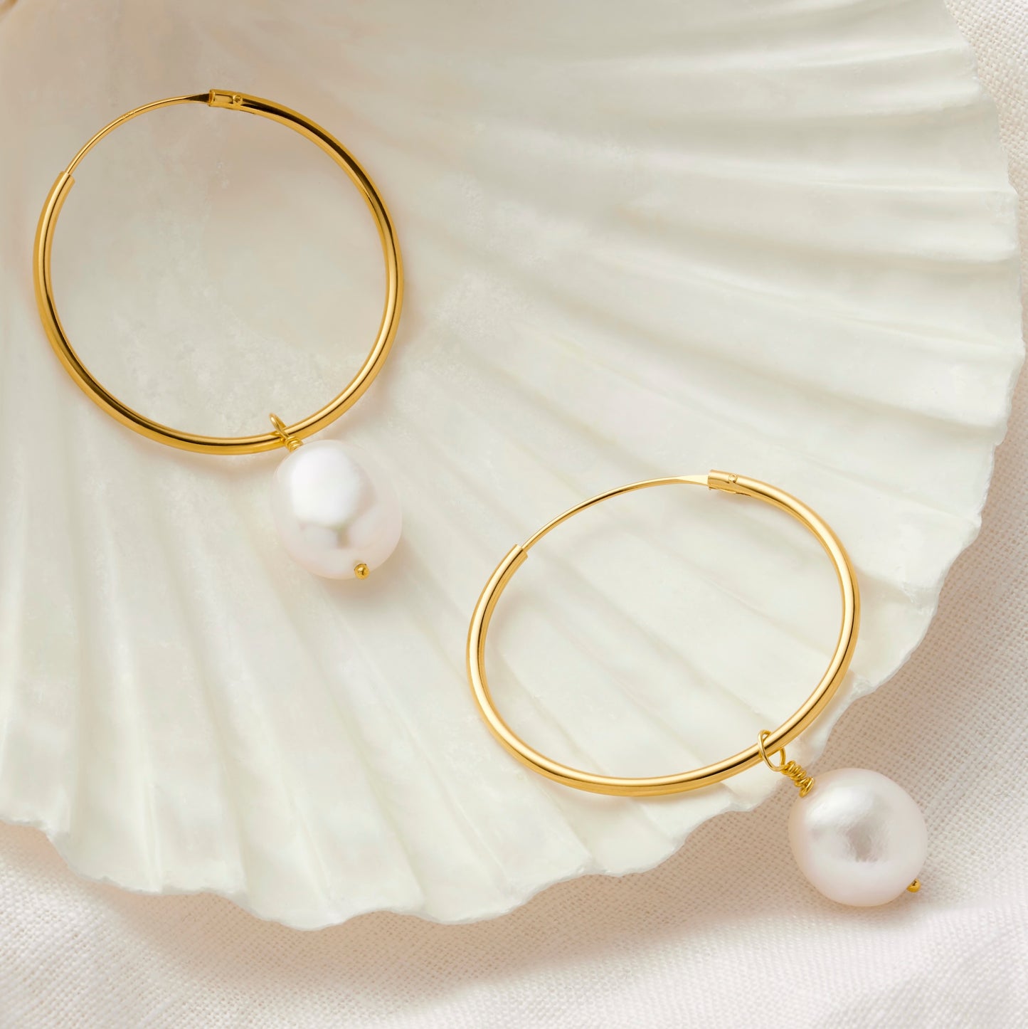 Large gold hoop earrings with white pearls