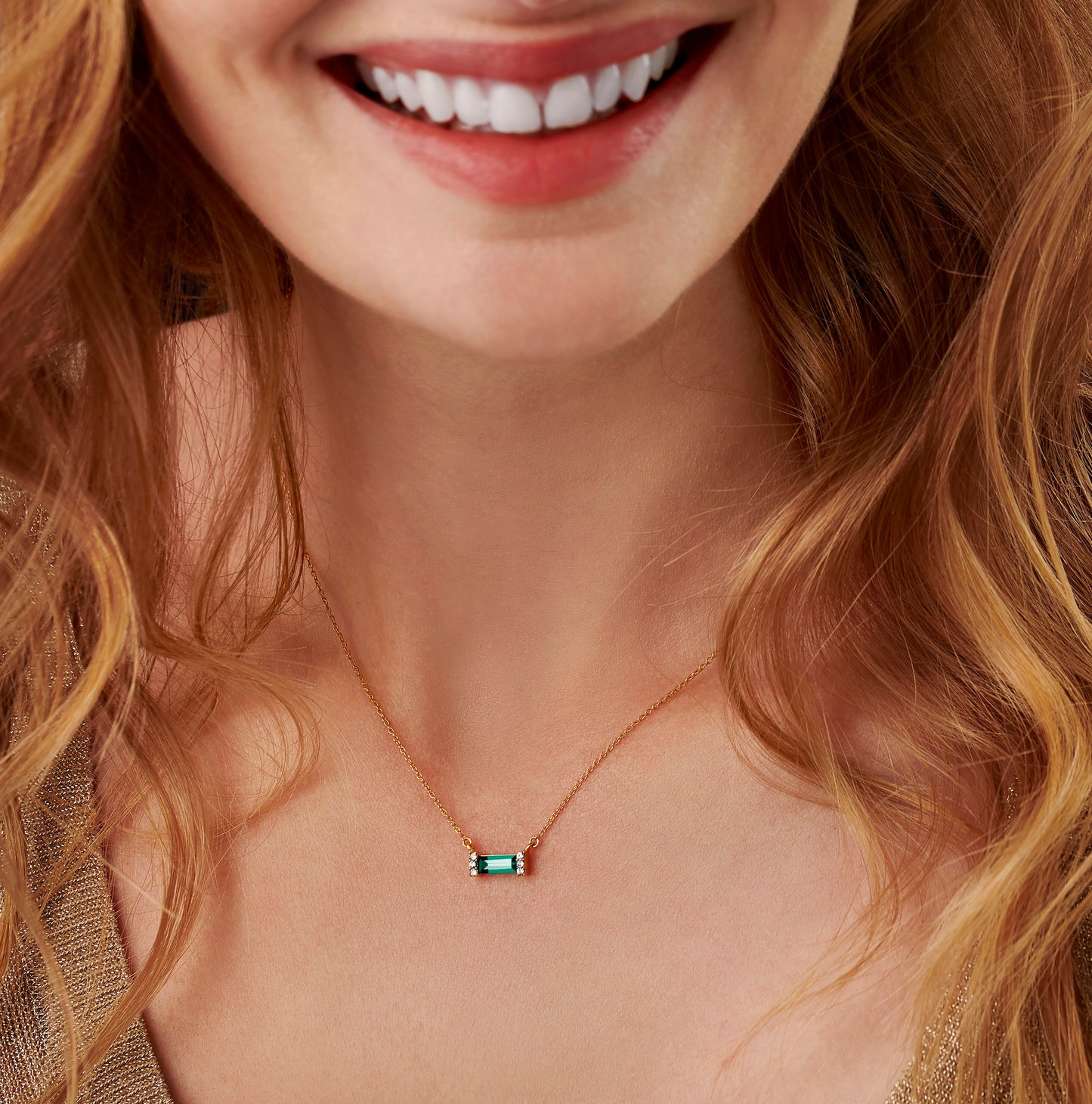 Lovely green emerald birthstone pendant featuring a baguette cut Swarovski crystal on a dainty gold trace chain by jewellery designer Claudette Worters.