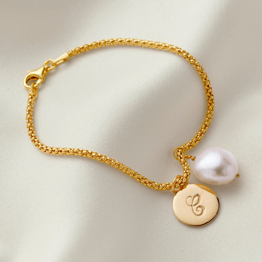 Gold bracelet with single white freshwater pearl and gold disc initial charm by Claudette Worters