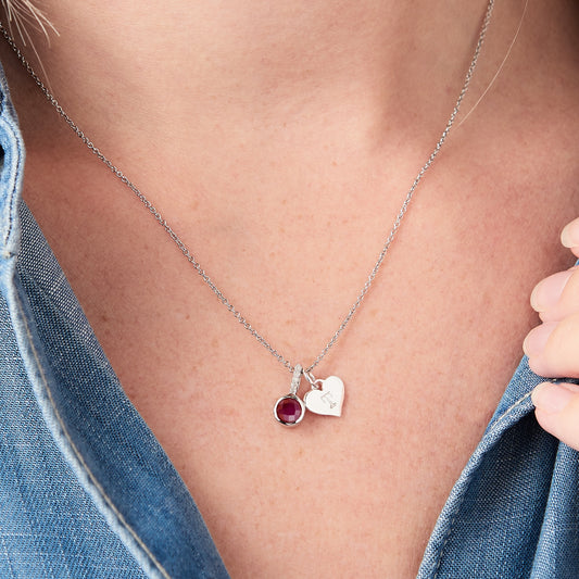 Red ruby pendant with diamonds and letter charm in silver