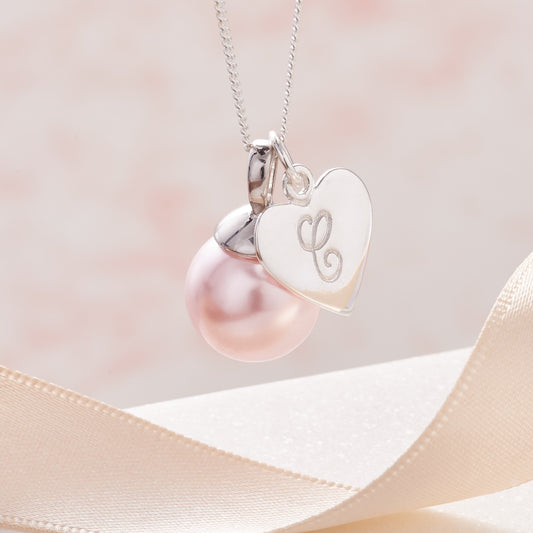 Pink pearl pendant with heart shaped charm personalised with an initial on a dainty sterling silver chain