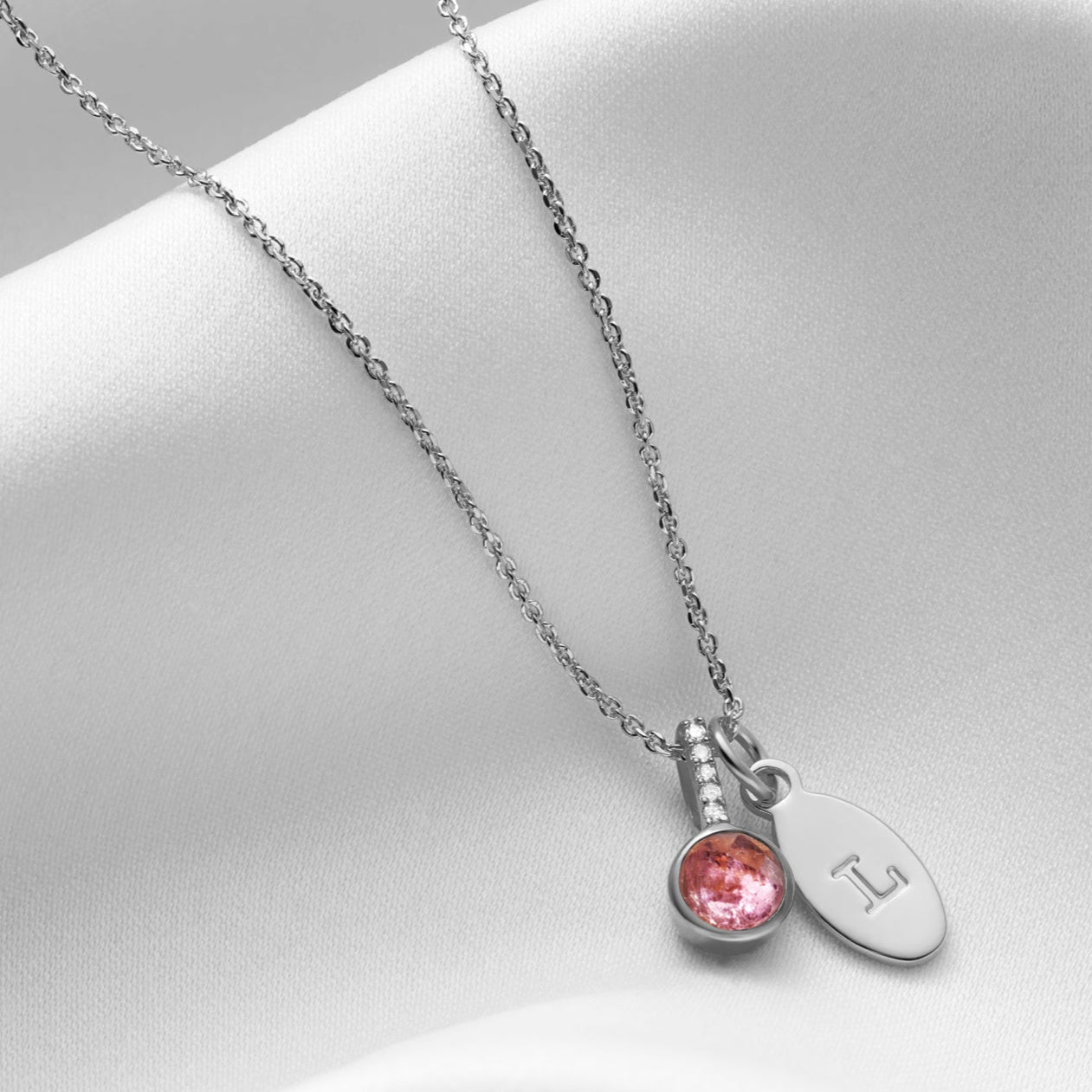 Pink Tourmaline October birthstone pendant necklace in silver with tiny white diamonds and oval initial charm