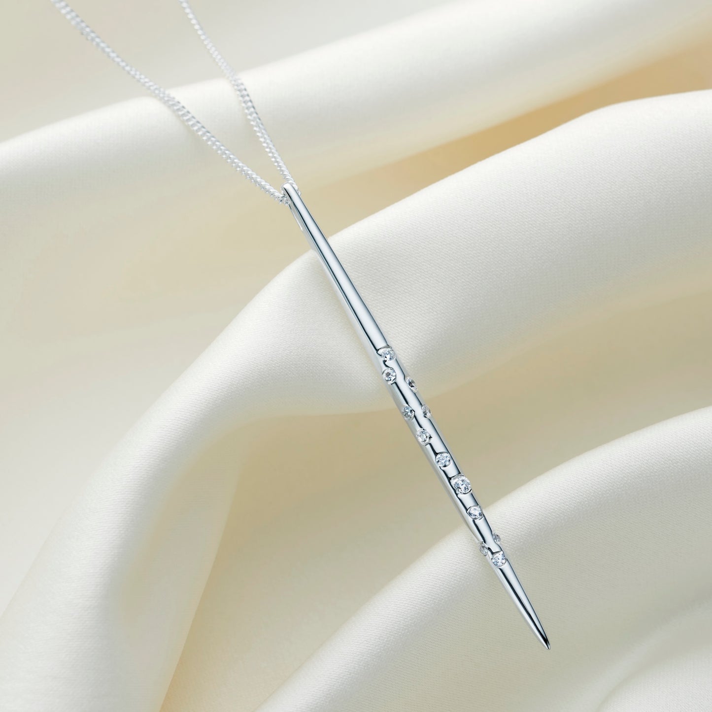 Long vertical bar style silver pendant necklace with white crystals set in the formation of the Taurus star constellation on a fine sterling silver chain by Claudette Worters
