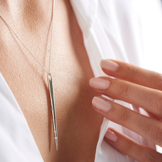 Long silver spike pendant with crystals depicting the Aquarius zodiac constellation.