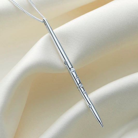 Close-up of highly polished sterling silver Virgo constellation necklace featuring a long, slender spike pendant hanging vertically with delicate star details, suspended on a fine sterling silver chain.