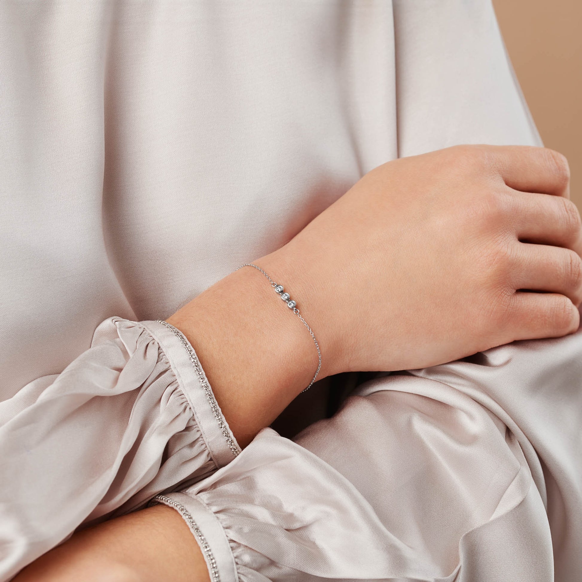 30th birthday bracelet featuring a row of three diamonds in rub over settings in sterling silver