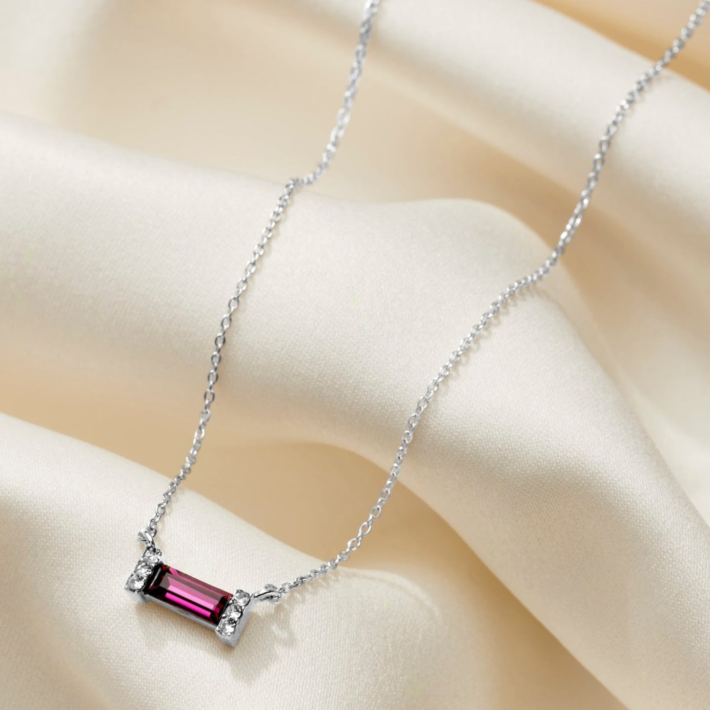 Birthstone necklace. Amethyst coloured baguette shaped crystal in an art deco style sterling silver setting, on a fine sterling silver trace chain.  