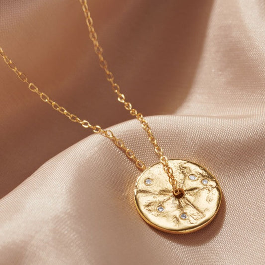 Gold disc coin pendant set with tiny white diamonds.  Pendant has a hole in the centre with a fine gold vermeil trace chain running through it.