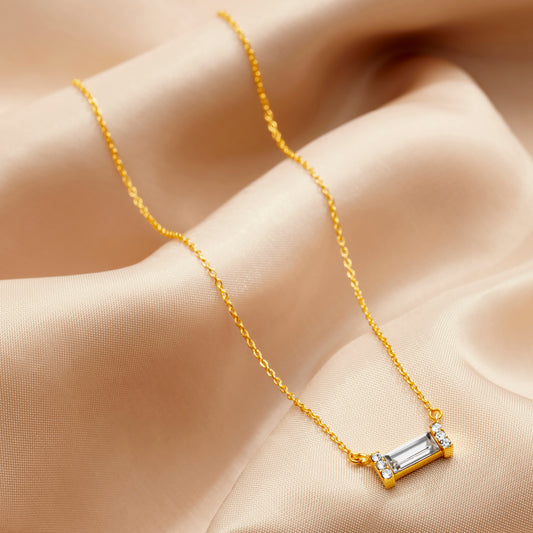 Clear crystal baguette stone necklace in an 18 carat yellow gold vermeil setting on a fine trace chain by Claudette Worters.