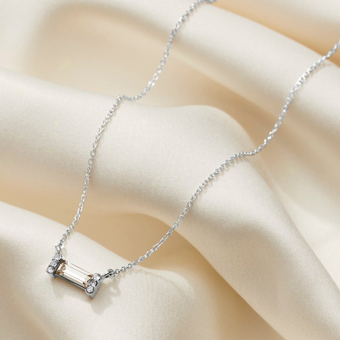 Silver necklace with a clear crystal baguette stone on a dainty silver trace chain.