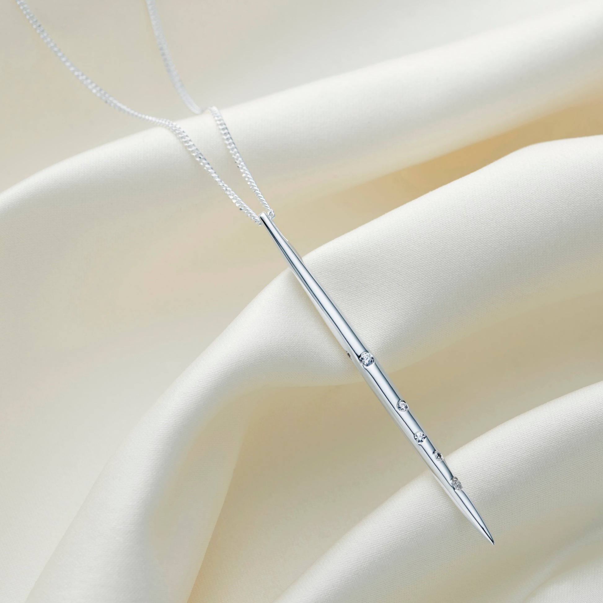 Long sterling silver pendant set with white crystals depicting the star constellation of Aries on a sterling silver chain by Claudette Worters.
