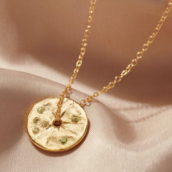 A gold disc spinner pendant with a sprinkling of pretty pale green peridot gemstones on a fine gold vermeil trace chain by Claudette Worters