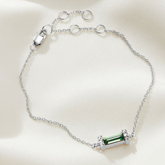 Sterling silver bracelet with green peridot baguette crystal with little pavé end settings on a sterling silver fine trace chain which fastens with a lobster claw clasp. 