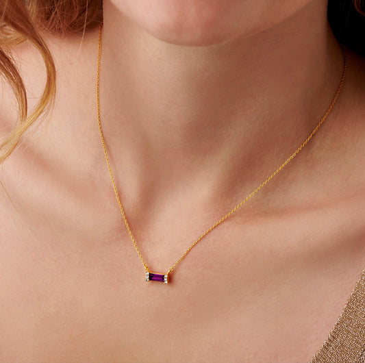 Gold necklace with baguette shaped purple amethyst birthstone with tiny white crystals in settings at the end of each stone.  Comes on a fine gold vermeil trace chain by Claudette Worters