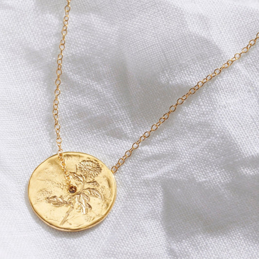 November birth flower pendant. A gold spinner disc pendant is hand engraved with a single Chrysanthemum stem. A fine gold trace chain runs through the centre of the pendant.