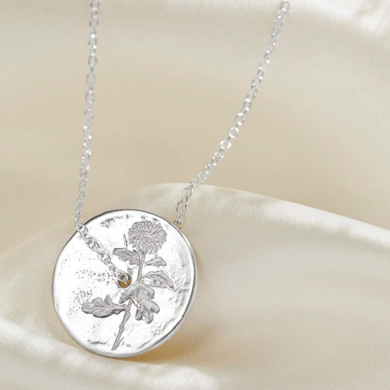 Solid silver circle disc pendant with hand engraved Chrysanthemum November birth flower.  There is a fine sterling silver trace chain running through the middle of the circle pendant.