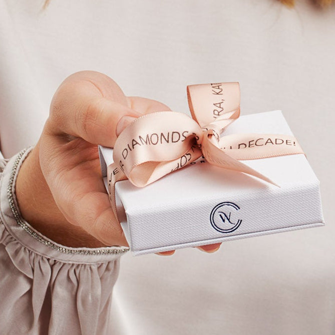 White gift box tied with a blush pink printed ribbon by Claudette Worters