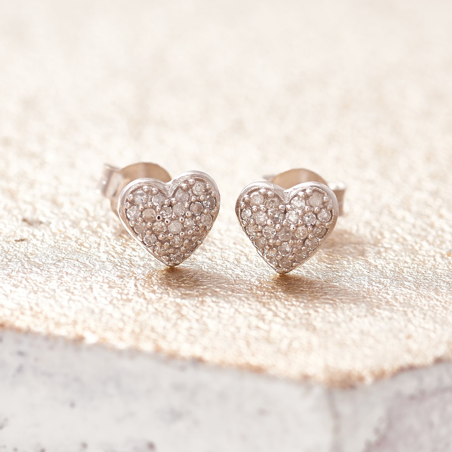 Sterling silver heart stud earrings pavé set with tiny white diamonds by Claudette Worters.