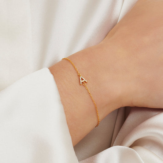 Gold capital letter A initial bracelet with tiny white diamonds on a fine gold trace chain