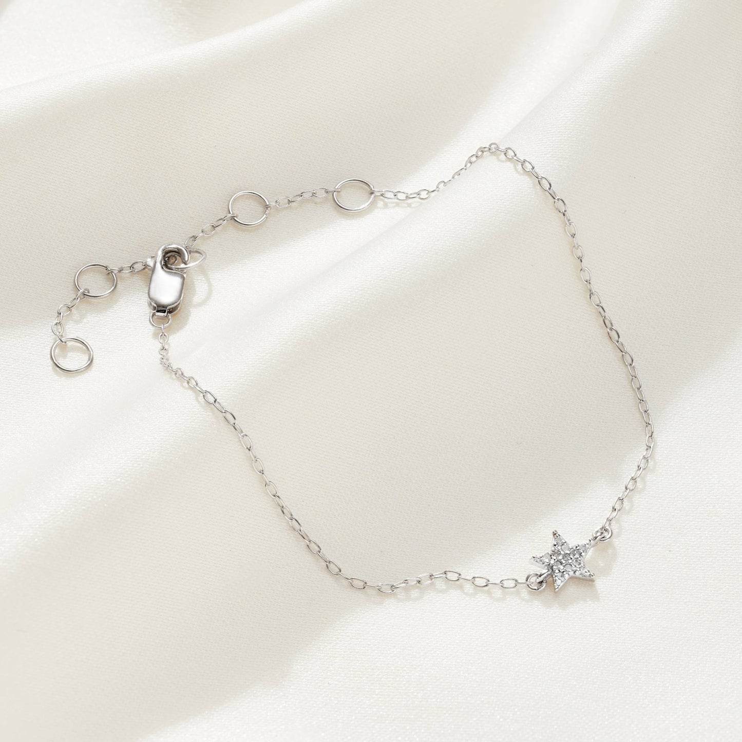 Sterling silver bracelet with a little star charm that has been pavé set with little white diamonds on a delicate silver trace chain with a lobster claw fastening.