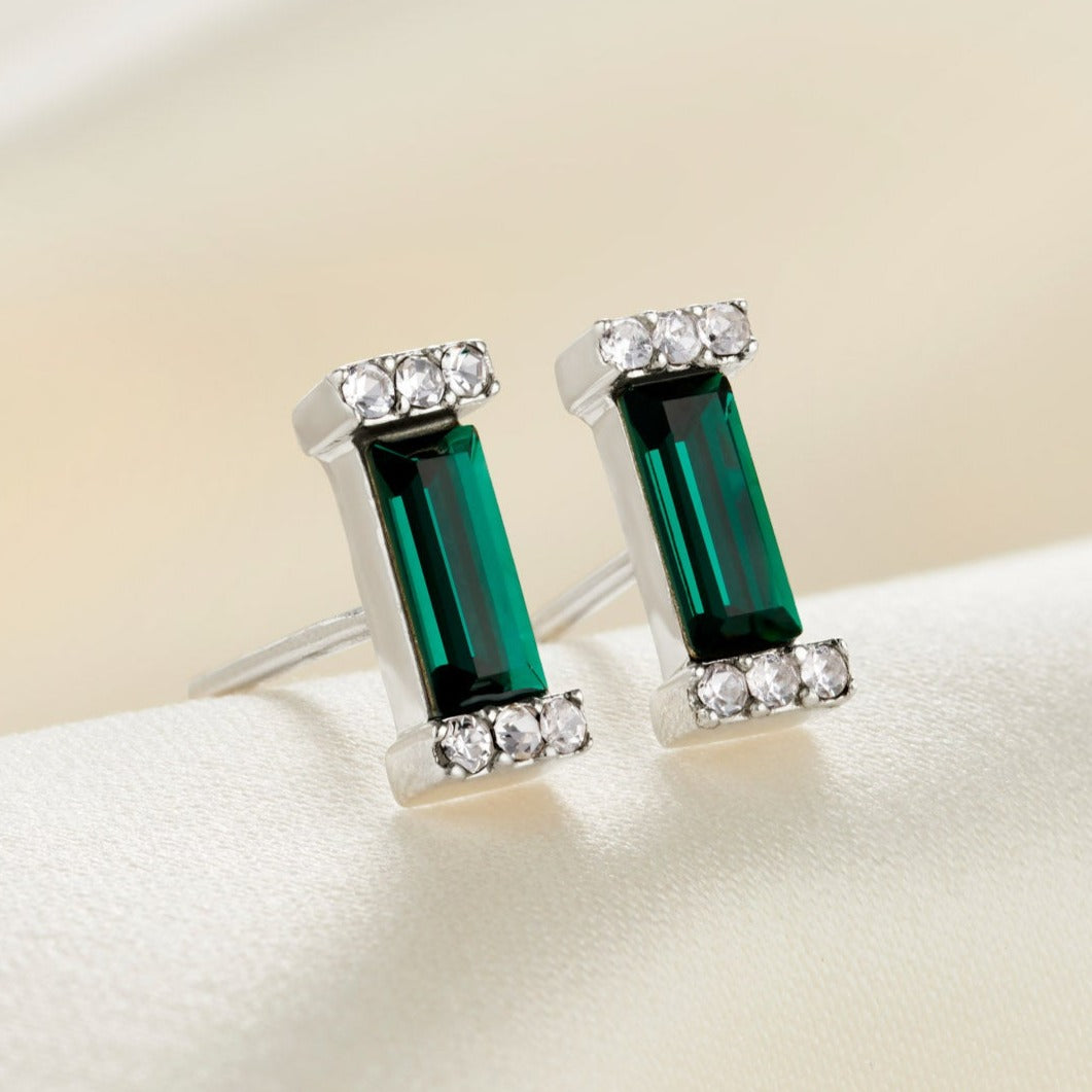 Sterling silver stud earrings with faceted emerald green baguette shaped crystals with pavé settings.