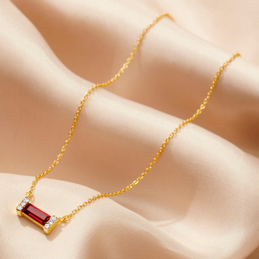 Gold necklace with a baguette cut garnet Swarovski crystal birthstone on a dainty gold vermeil trace chain by Claudette Worters.