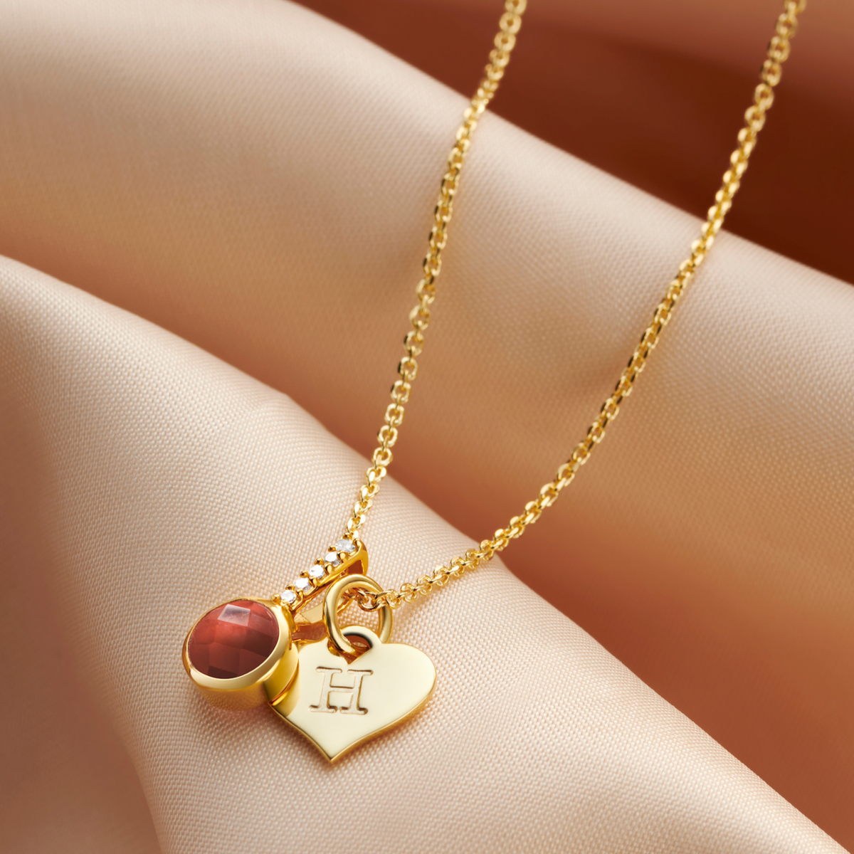 Garnet birthstone necklace with tiny white diamonds and personalised heart initial charm by Claudette Worters