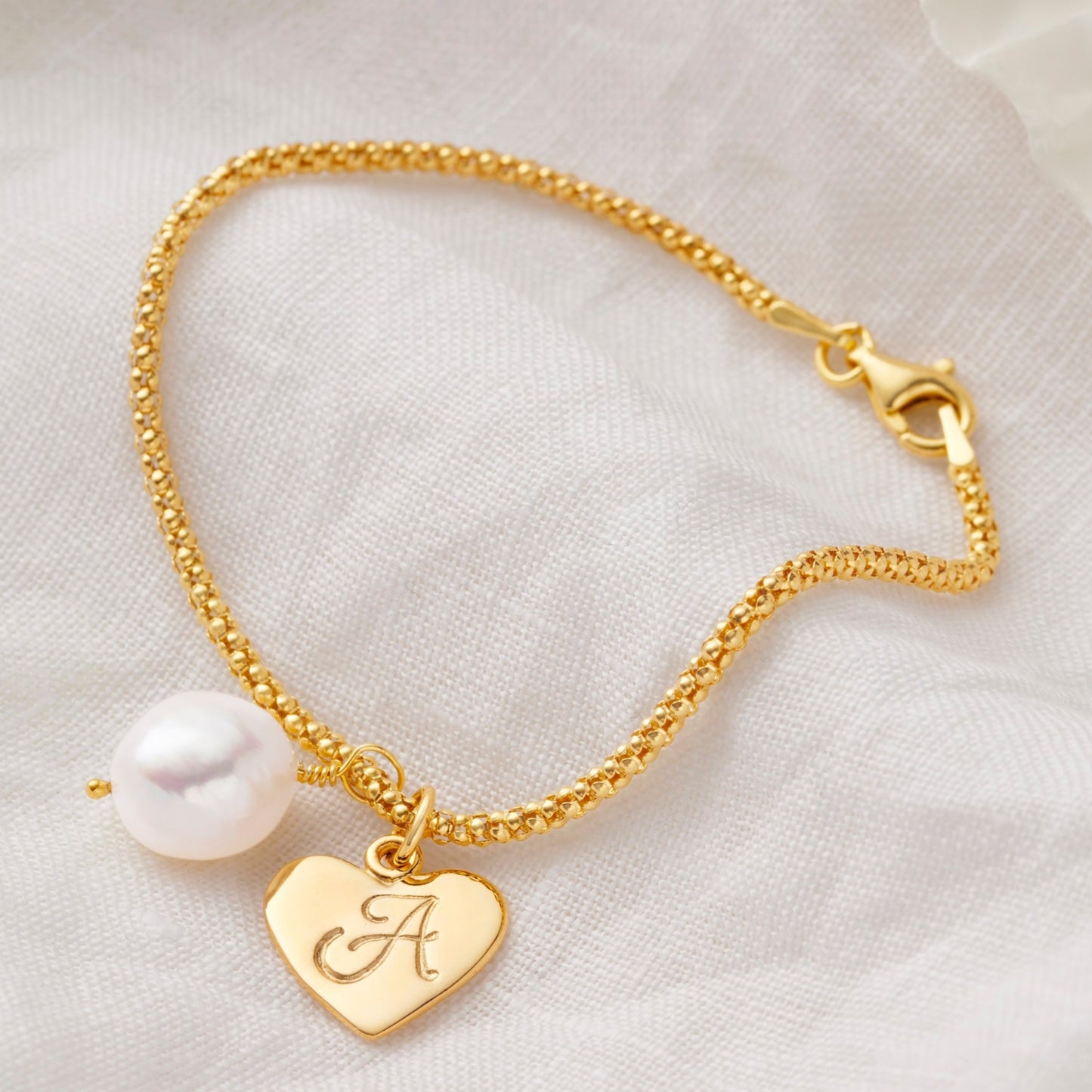 Freshwater pearl gold bracelet with a heart shaped charm personalised with the letter A