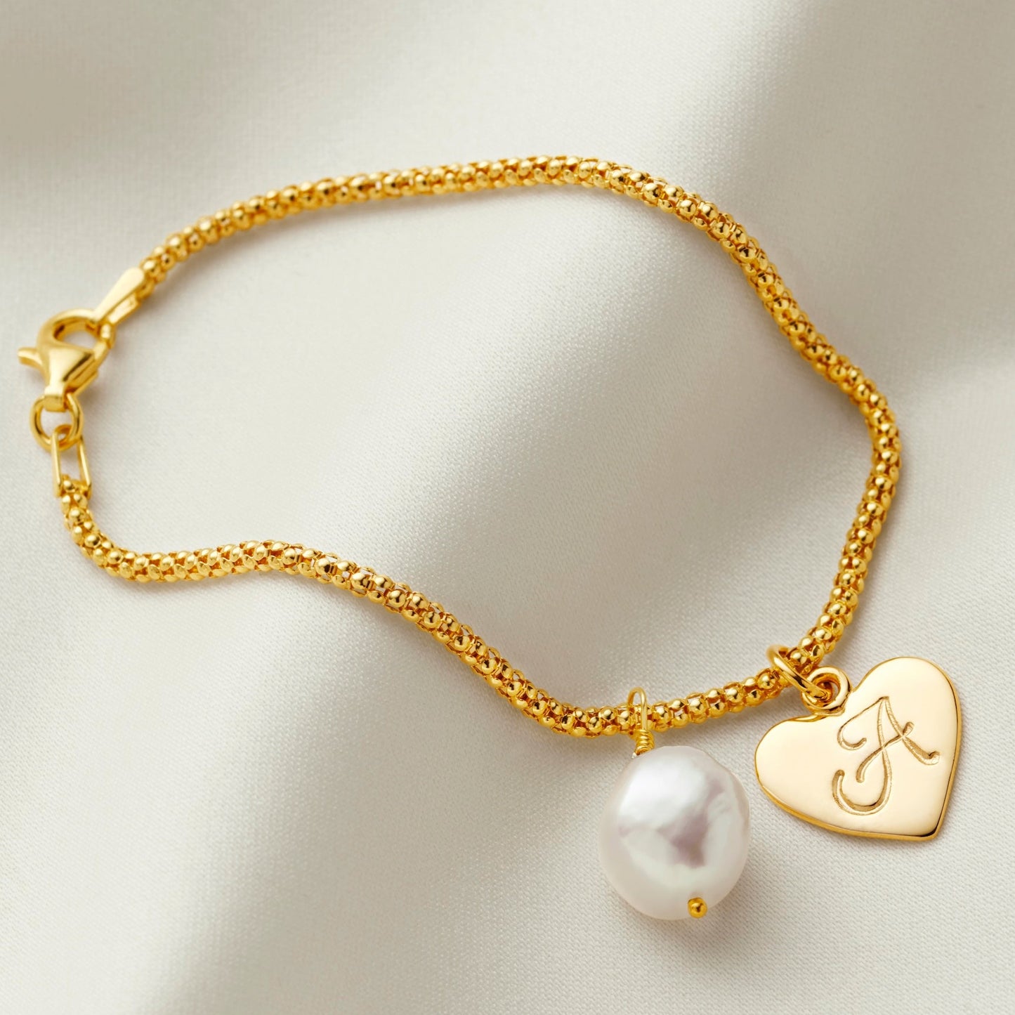 Gold vermeil popcorn chain style bracelet with a heart charm hand stamped with an upper case scrolling font letter A along side a lovely iridescent off white freshwater pearl by Claudette Worters.