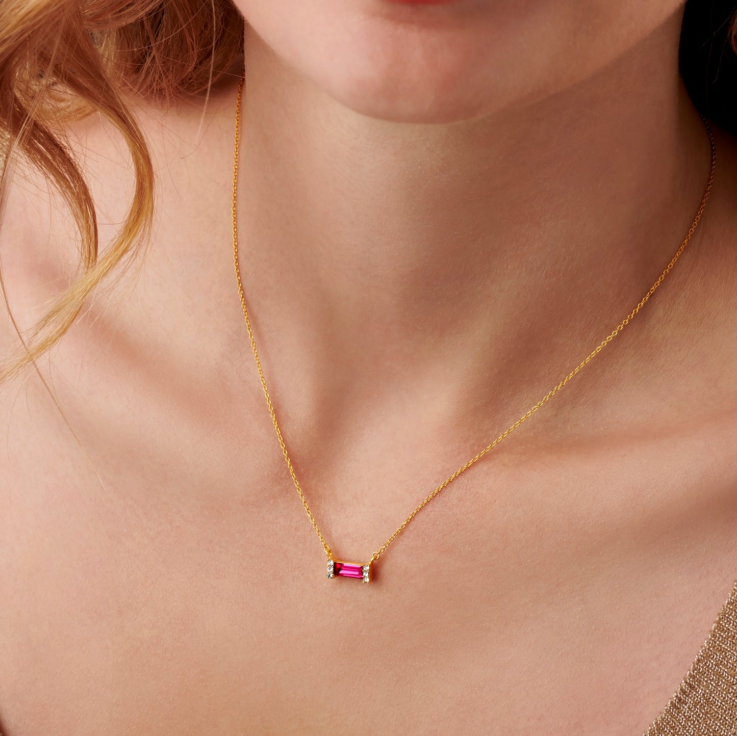 Ruby baguette stone pendant necklace in gold vermeil on a dainty gold trace chain by Claudette Worters.