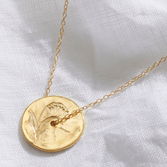 Gold spinner disc pendant necklace with a hand engraved Lily of the Valley motif.   A fine gold trace chain threads through the centre of the pendant.