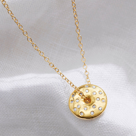 Gold vermeil Full Moon necklace by Claudette Worters featuring a textured spinning lunar disc pendant with real diamonds to symbolise the moon phase.