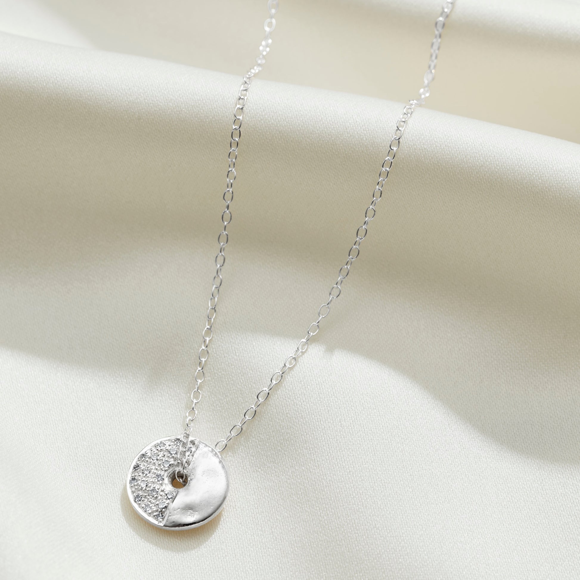 Moon phase necklace in sterling silver with diamonds depicting the third quarter of the moon by Claudette Worters
