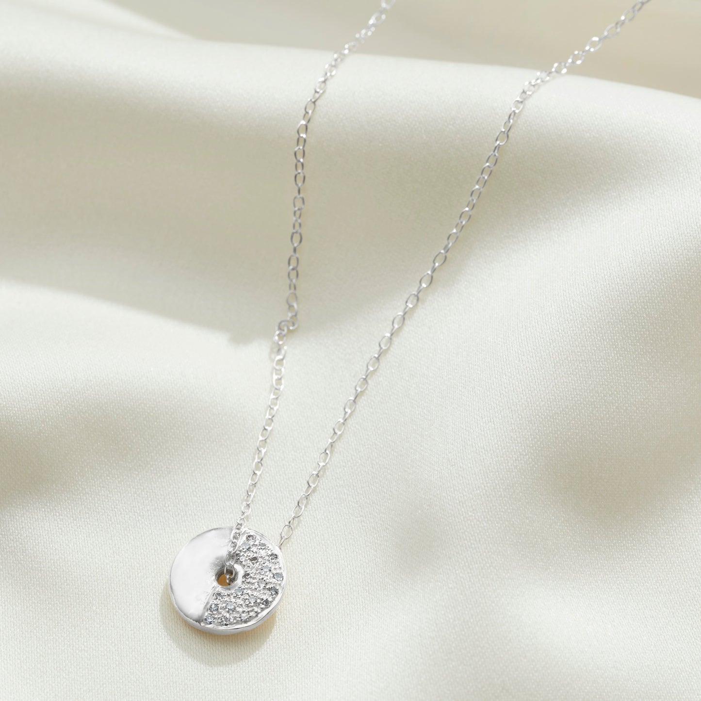 First Quarter moon phase necklace in sterling silver set with diamonds on a fine trace chain by Claudette Worters