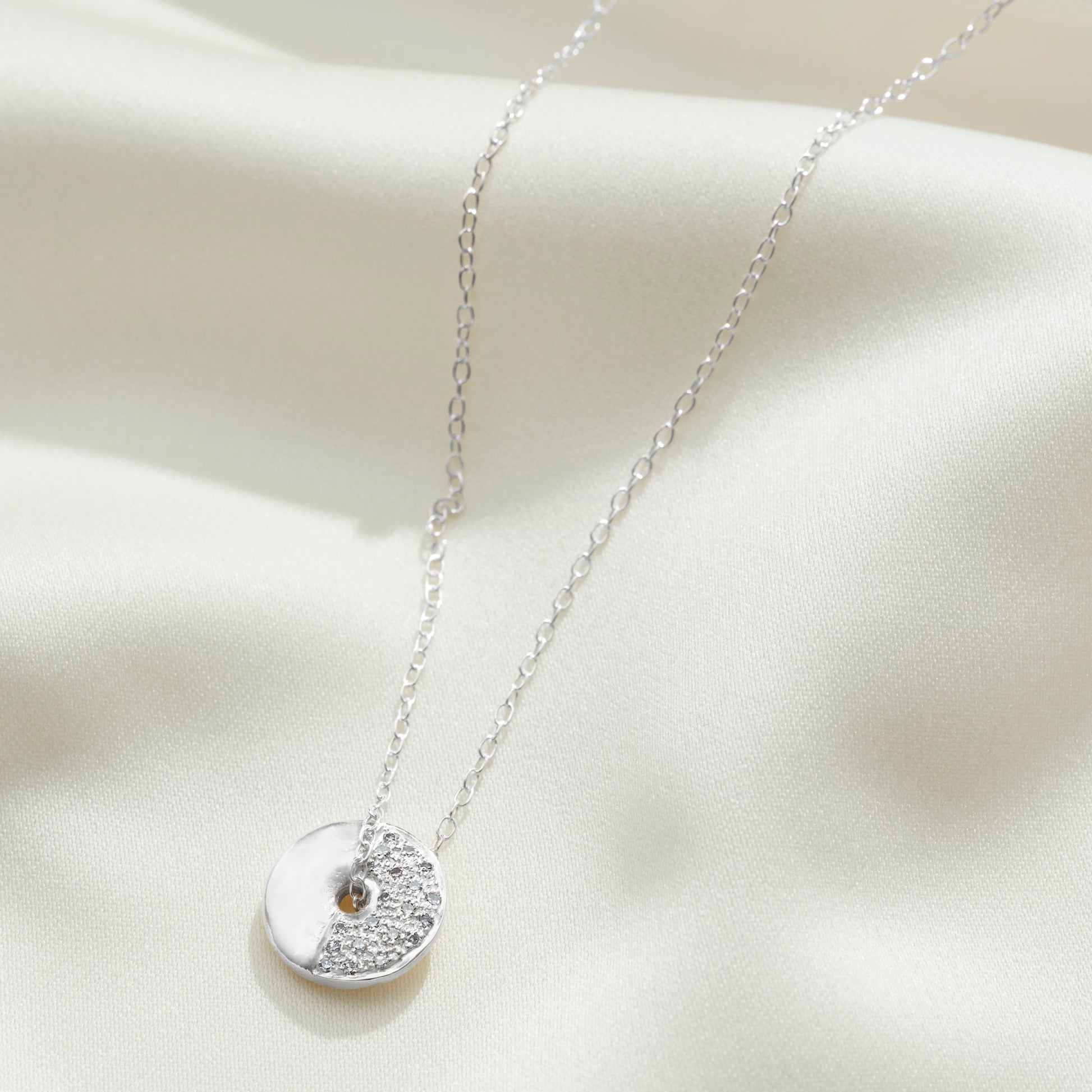 First Quarter moon phase necklace in sterling silver set with diamonds on a fine trace chain by Claudette Worters