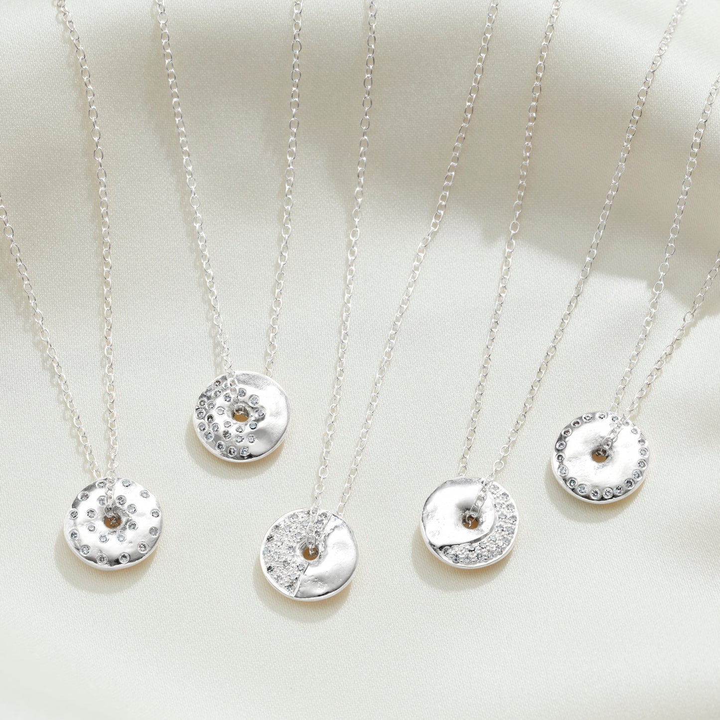 5 moon phase necklaces in silver with white diamonds on sterling silver trace chains by Claudette Worters