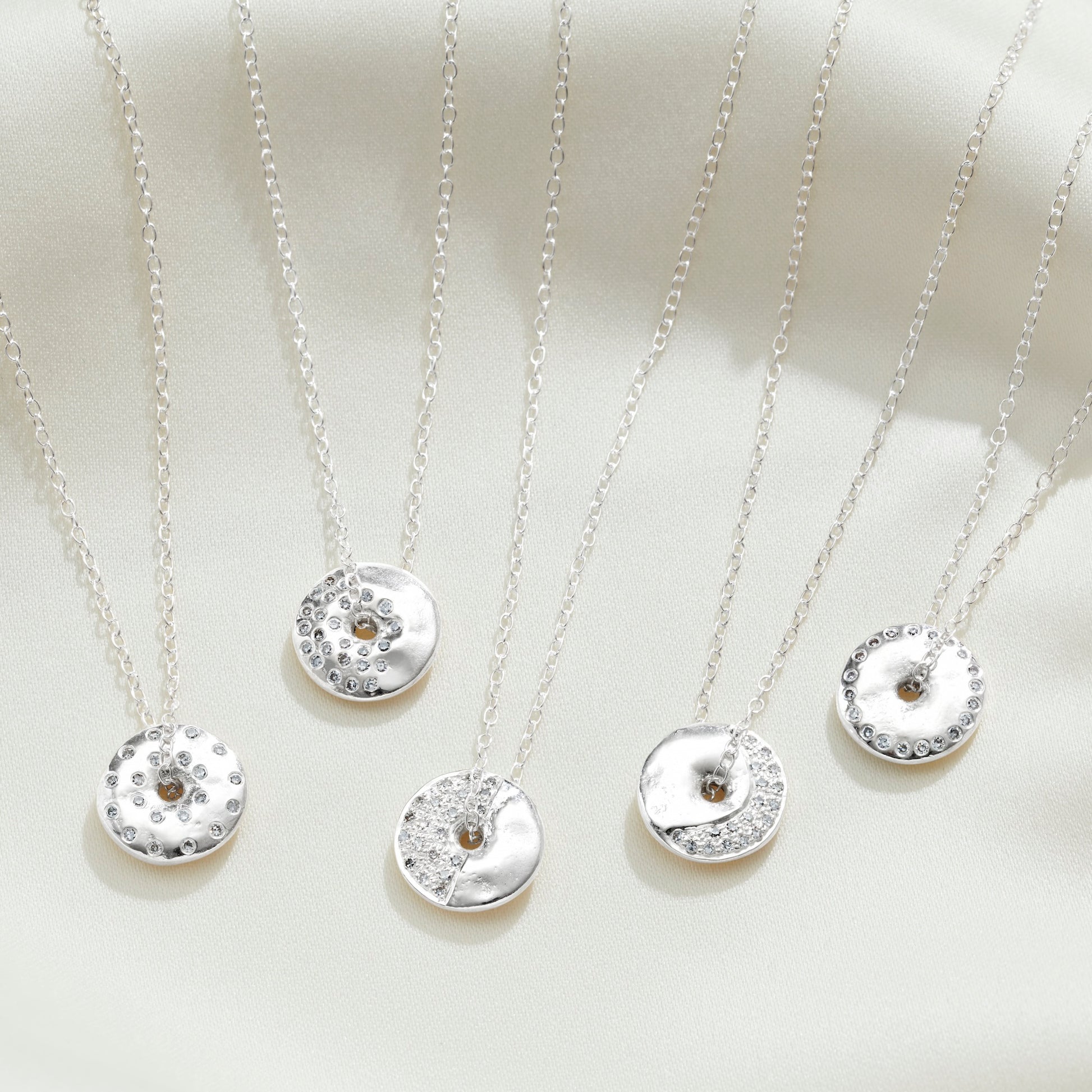 5 moon phase necklaces in silver with white diamonds on sterling silver trace chains by Claudette Worters