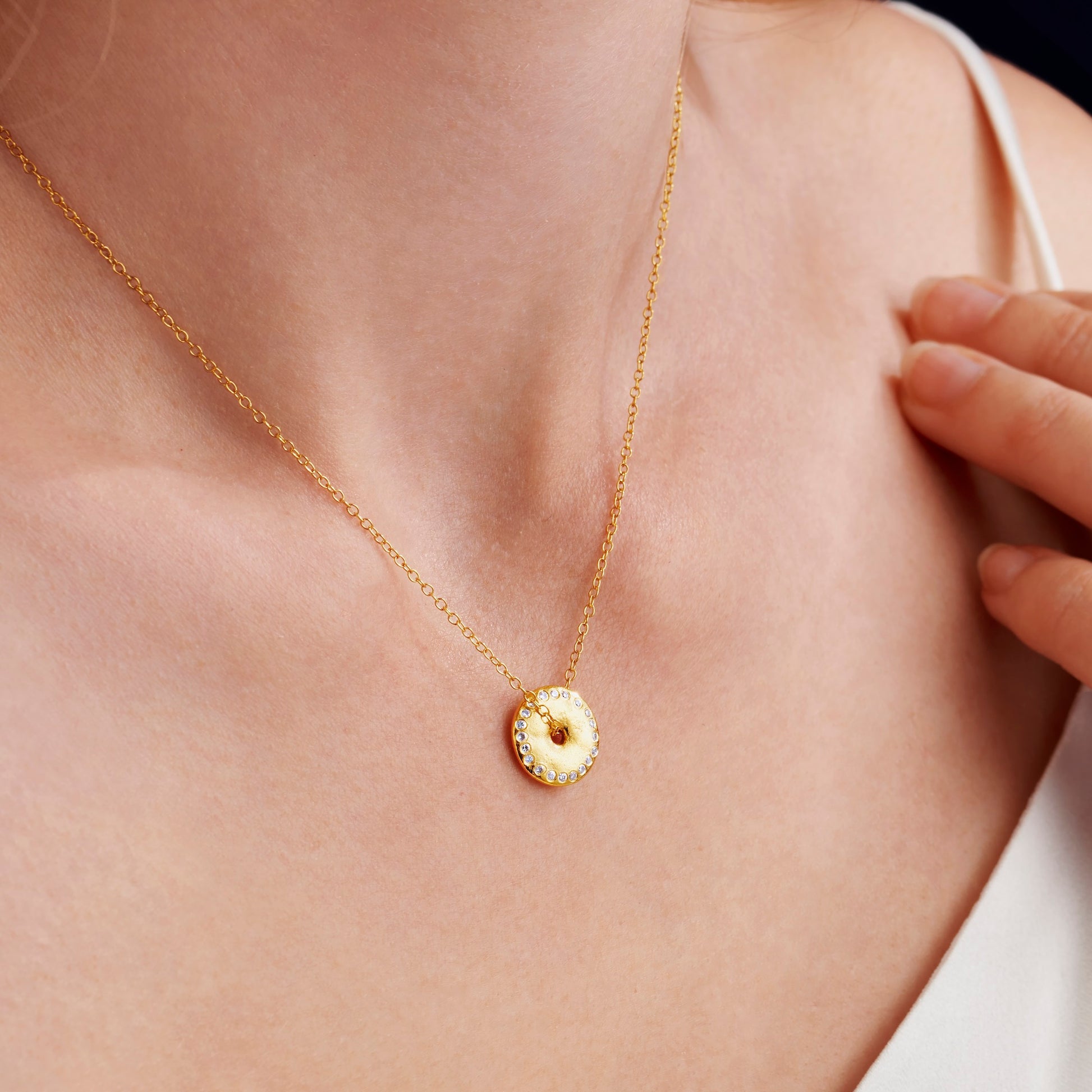 Claudette Worters gold vermeil abstract moon phase pendant necklace worn on model, with spinning textured disc and diamond detail.