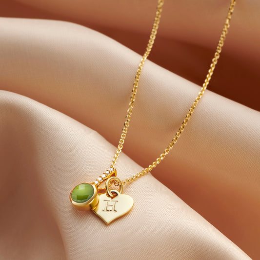 Peridot birthstone necklace in gold vermeil with a little heart charm hand stamped with an initial on a dainty trace chain