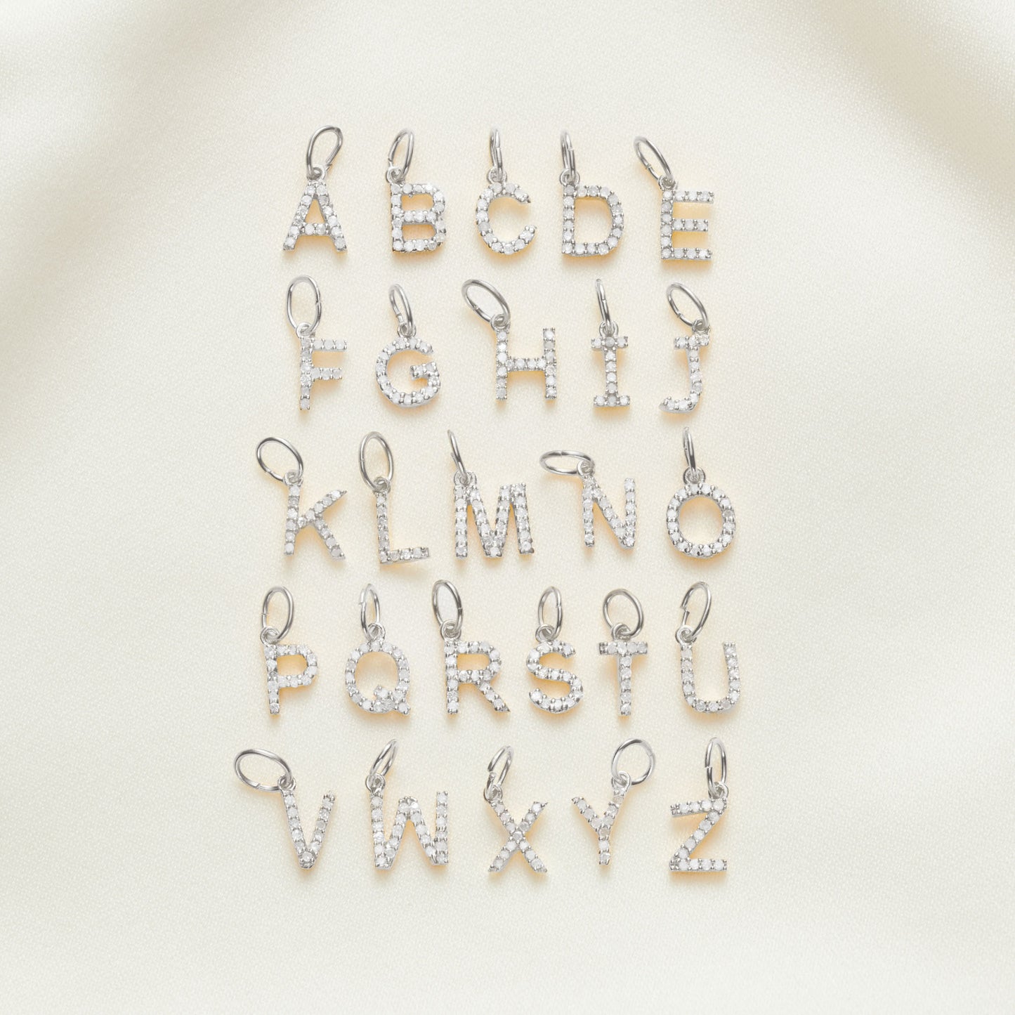 Sterling silver letter charms, pavé set with tiny, real, white diamonds.  Letters are the full alphabet from A-Z in capital letters.  By Claudette Worters.