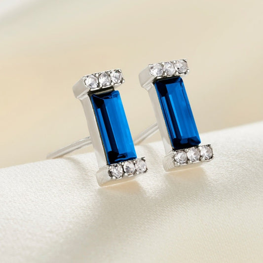 Sterling silver stud earrings with crystal pavé settings on the ends of a baguette shaped sapphire crystal stone with sterling silver posts