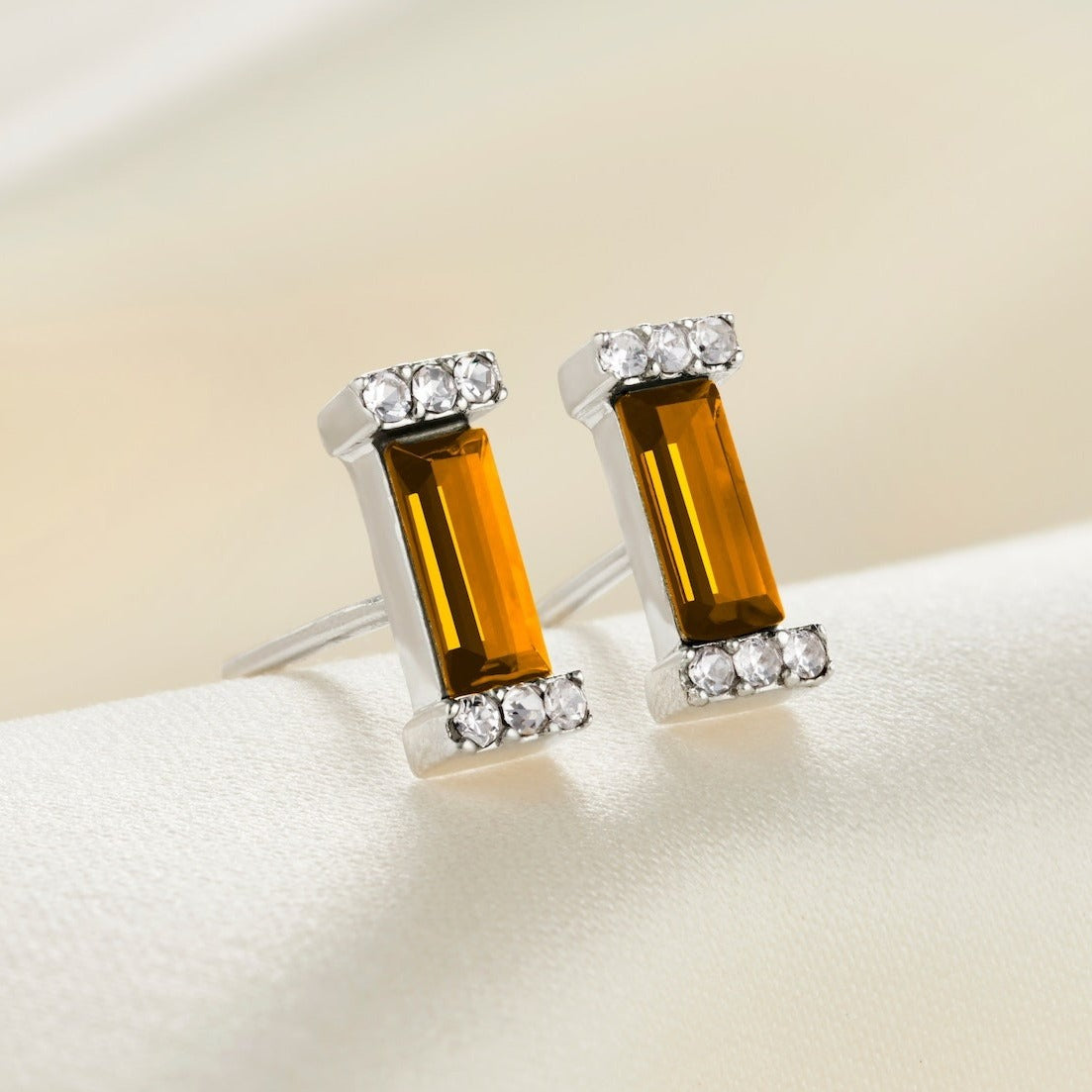 Sterling silver stud earrings with silver post fittings and crystal pavé settings with faceted baguette shaped topaz crystals