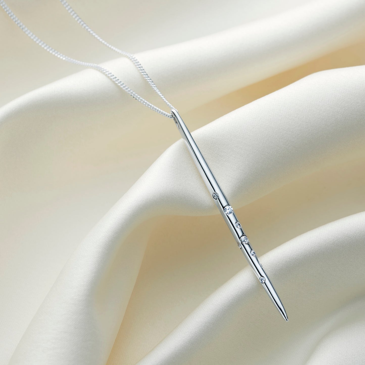 Highly polished sterling silver Virgo constellation necklace with a vertical spike pendant decorated with crystals representing the Virgo constellation, suspended on a delicate silver chain.